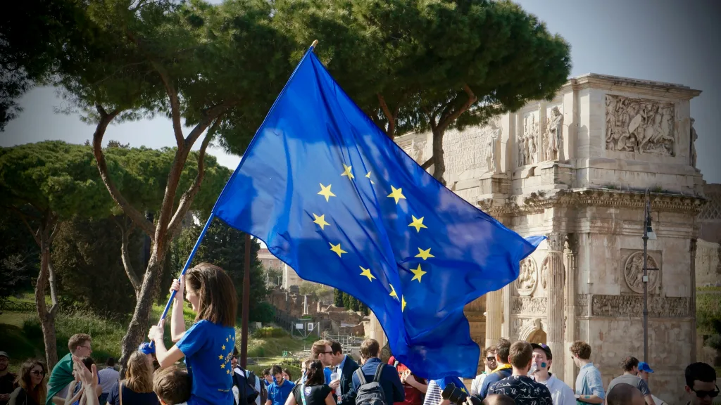 Demonstration in Rome showing a young crowd with an European Union flag being waved in the center.