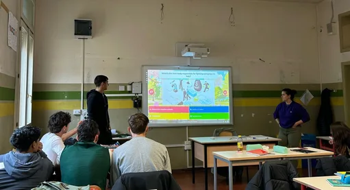 Back view of projected presentation in the center with two workshop participants, one standing on each side, and four sitting in front.