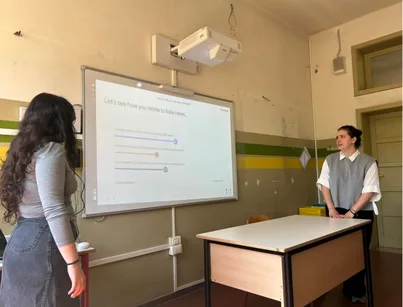 Projected presentation with two workshop participants, standing on each side.