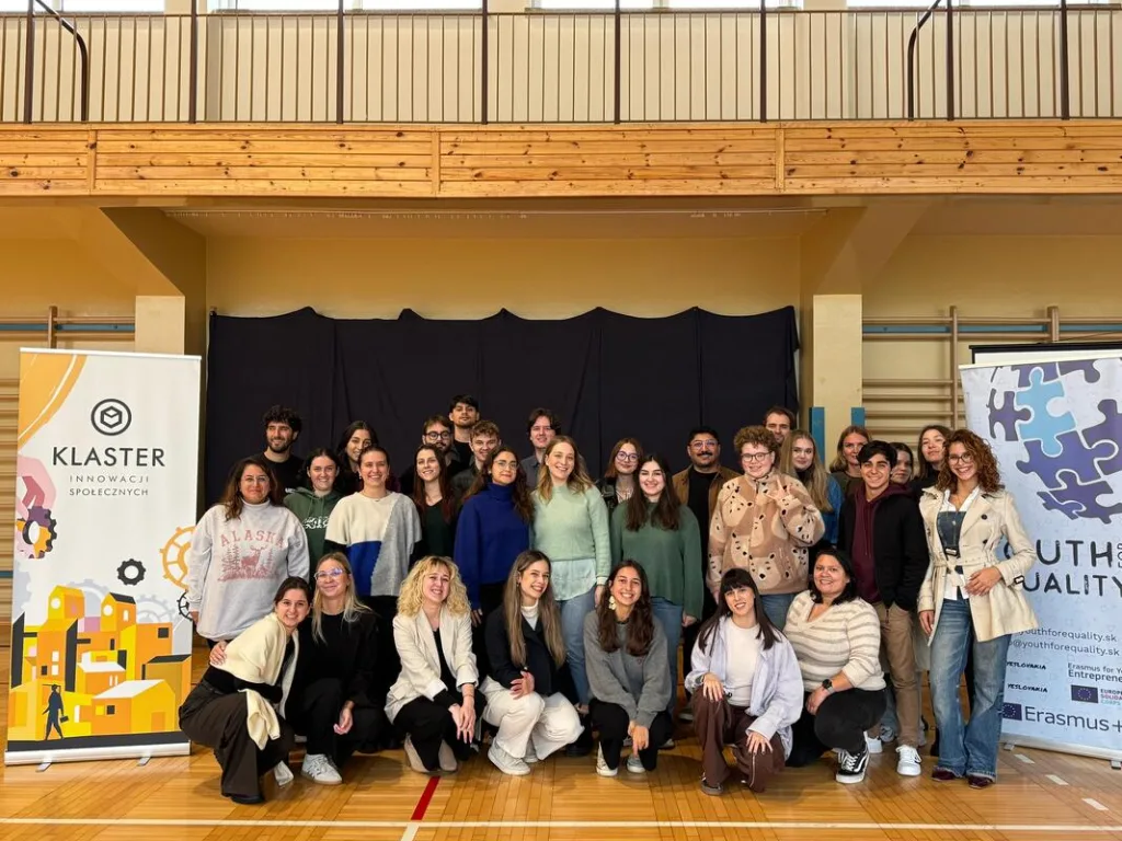 Group photo of the partners during the event, with banners showing the organization's logos on each side.